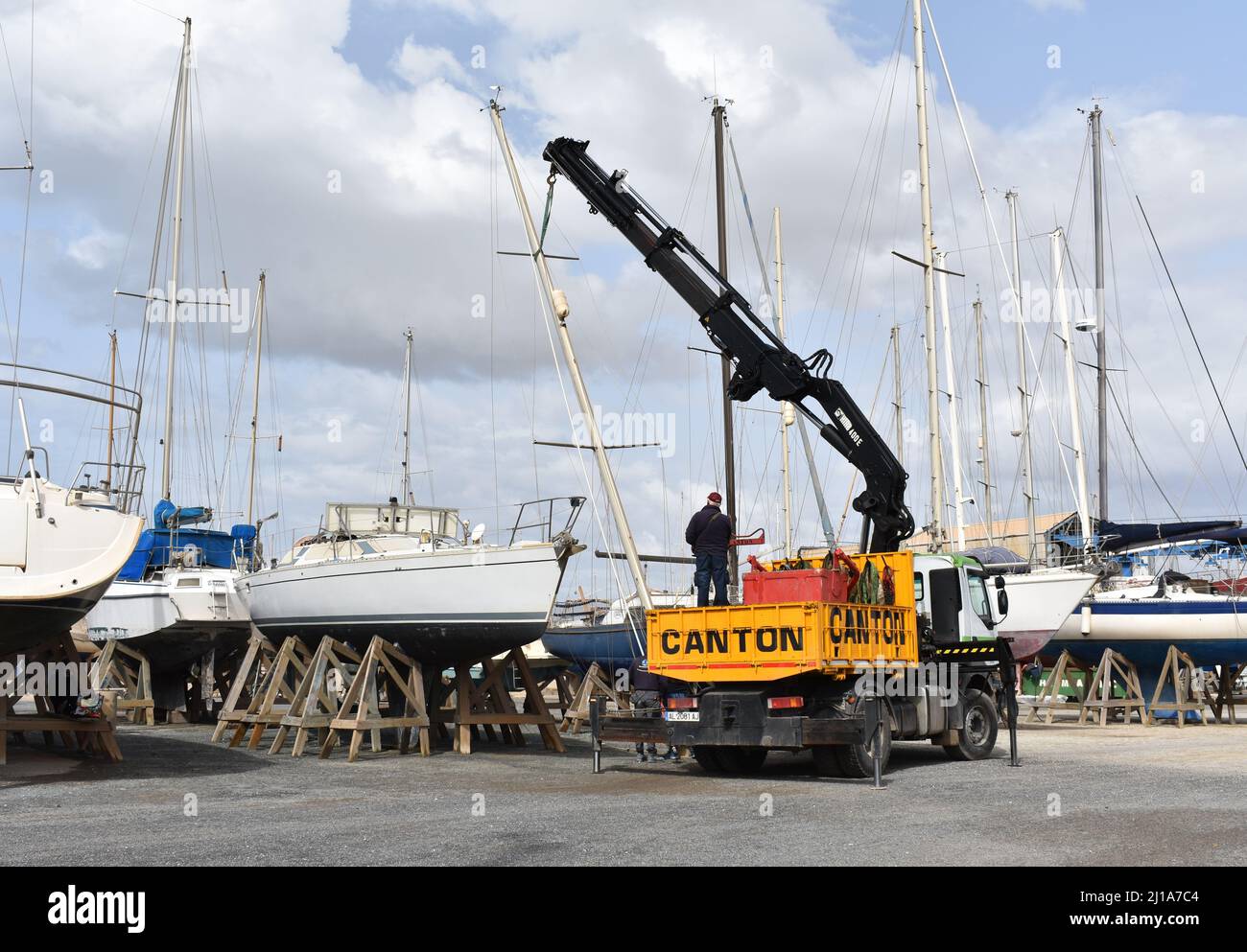 Yacht mast being removed by a crane, Almerimar marina boatyard, Almeria, Spain Stock Photo