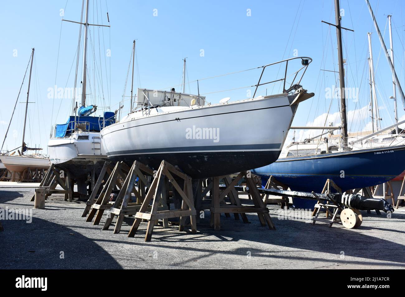 Sailing yacht with mast removed stored in Almerimar marina boatyard, Almerimar, Spain Stock Photo