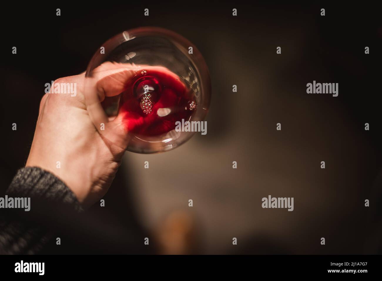 hand with a glass of red wine at a wine tasting Stock Photo