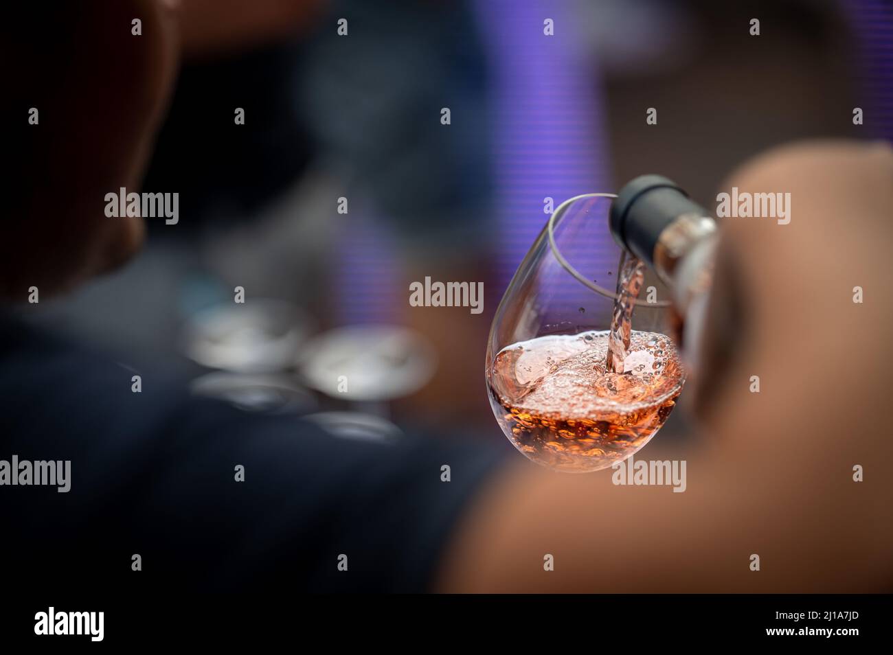 hand with a glass of rosé wine at a wine tasting Stock Photo