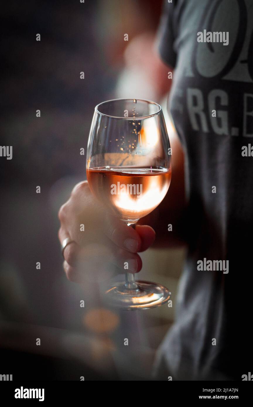 hand with a glass of rosé wine at a wine tasting Stock Photo