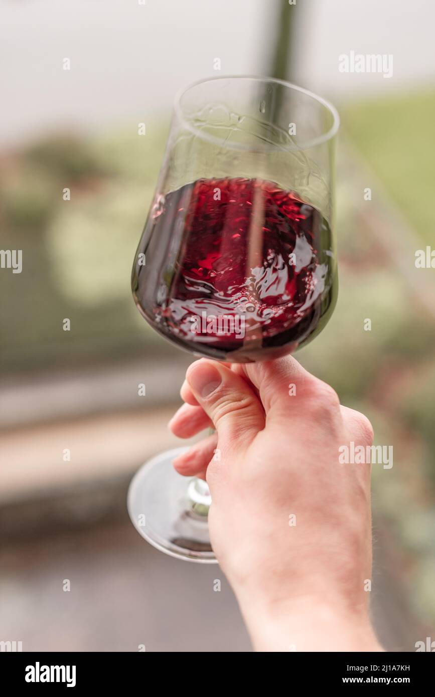 hand with a glass of red wine at a wine tasting Stock Photo