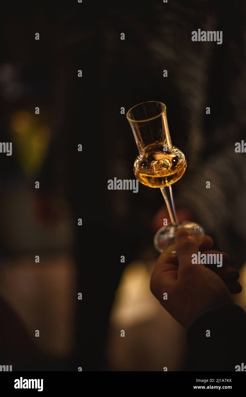 hand with a glass of grappa wine at a tasting Stock Photo
