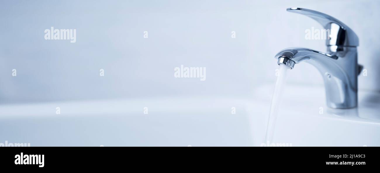 Water tap, stainless steel faucet. Water flow in bathroom with sink