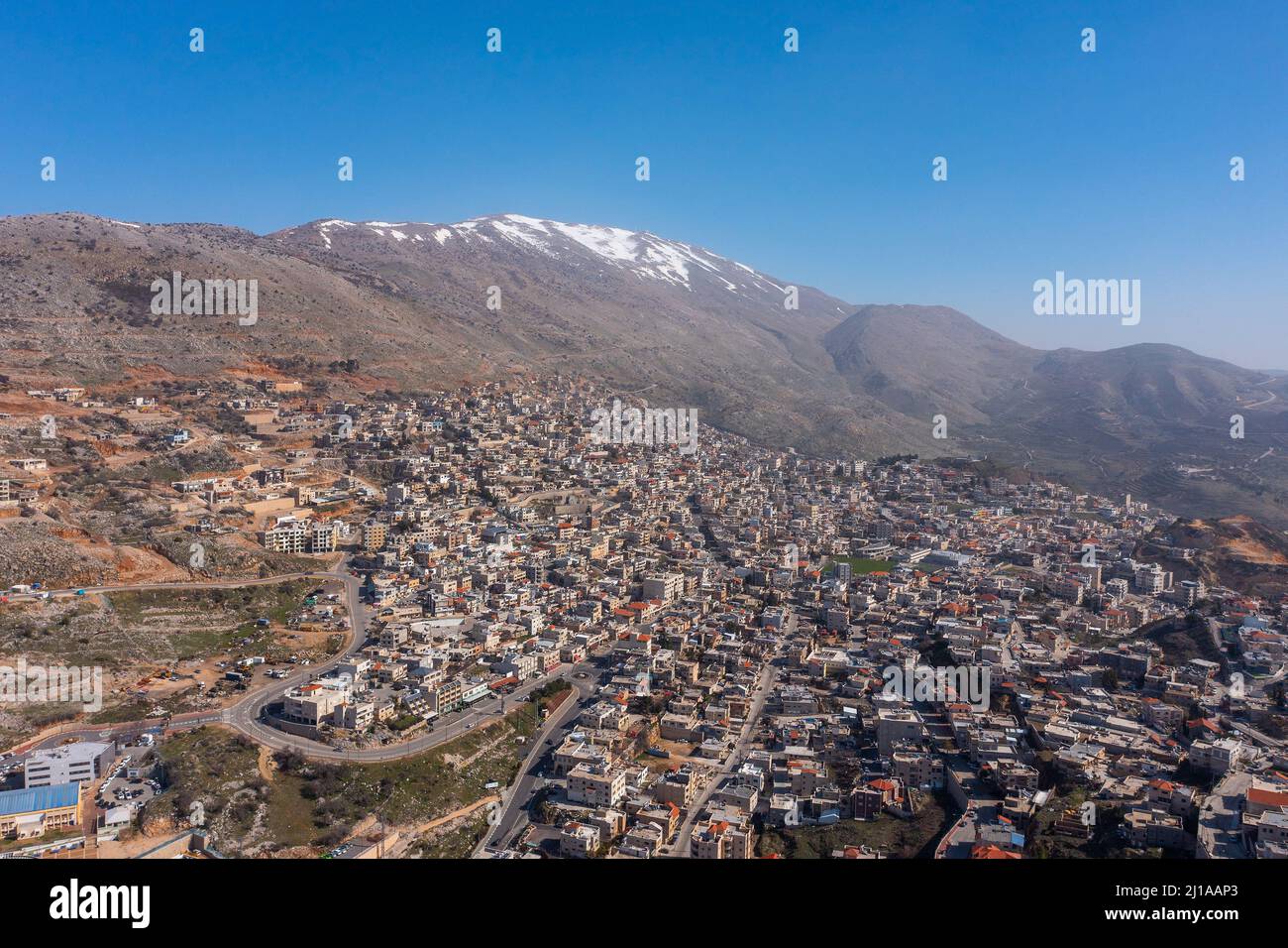 Hermon mountain ridge covered with snow during 2022 winter, with the town houses of Majd al Shams. Stock Photo