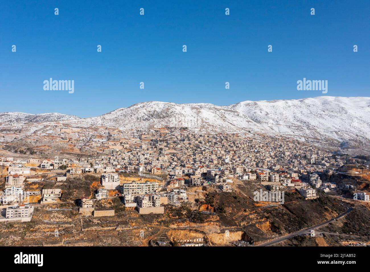 Hermon mountain ridge covered with snow during 2022 winter, with the town houses of Majd al Shams. Stock Photo