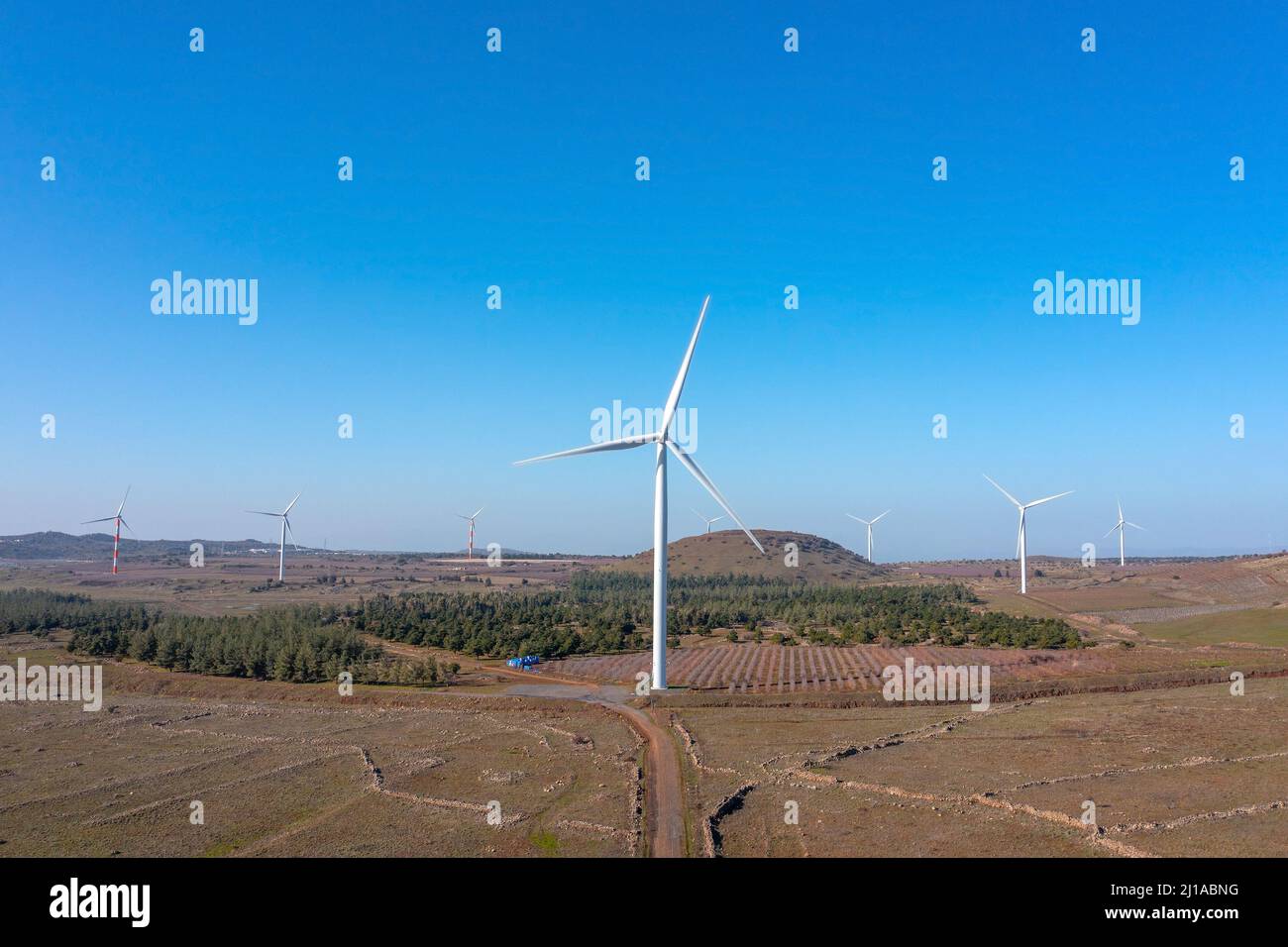 Wind turbines spin in a rural mountain landscape, Aerial view. Stock Photo