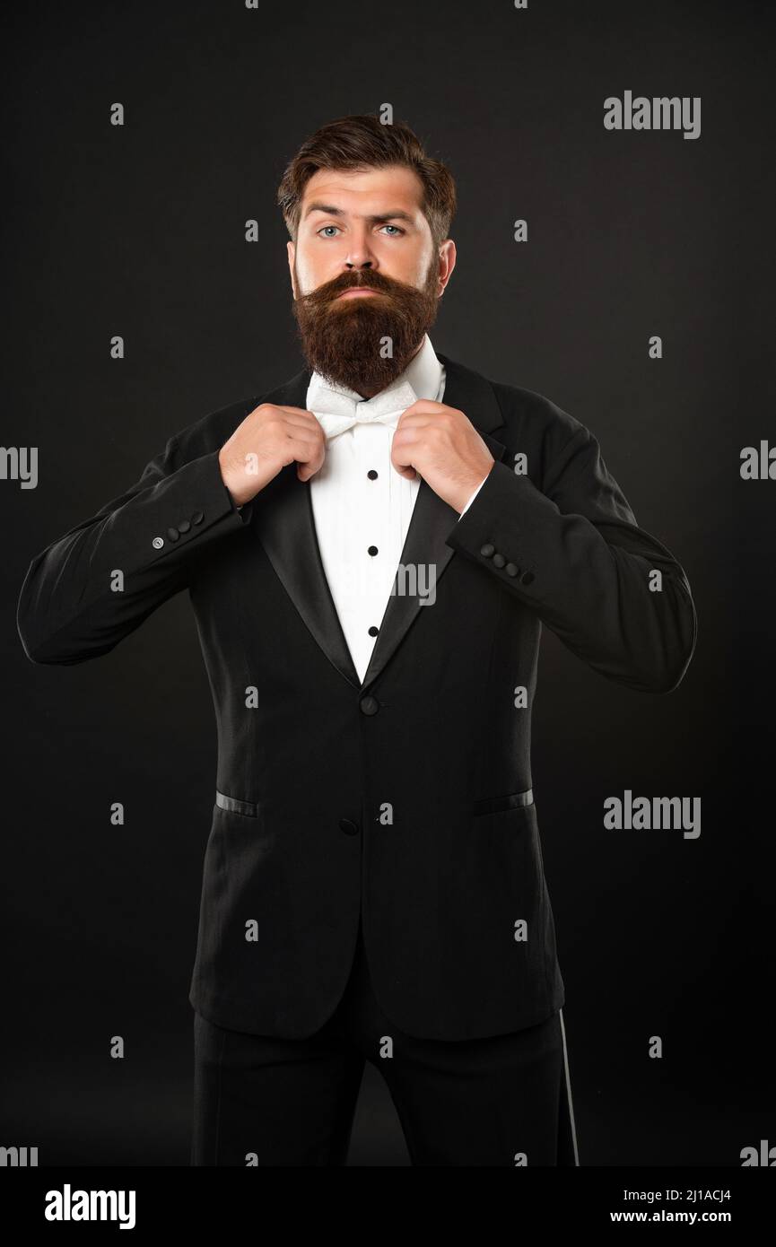 elegant butler in tuxedo on black background, bow tie Stock Photo - Alamy