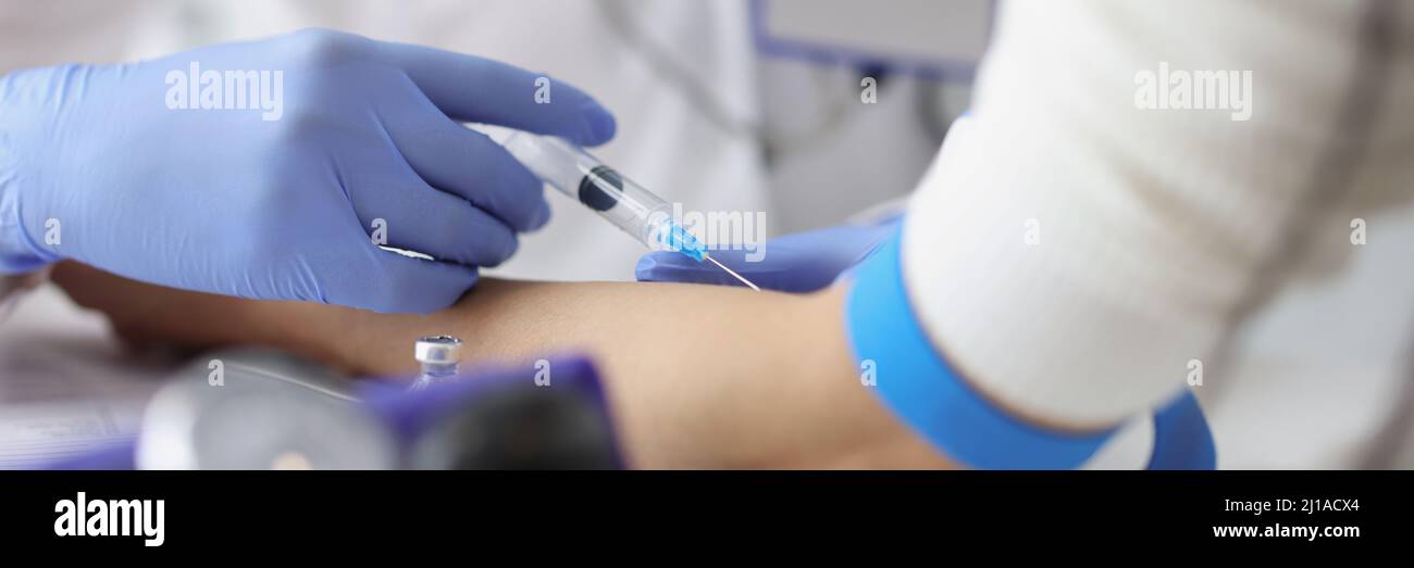 Nurse giving intravenous injection into patient ulnar vein at clinic ...