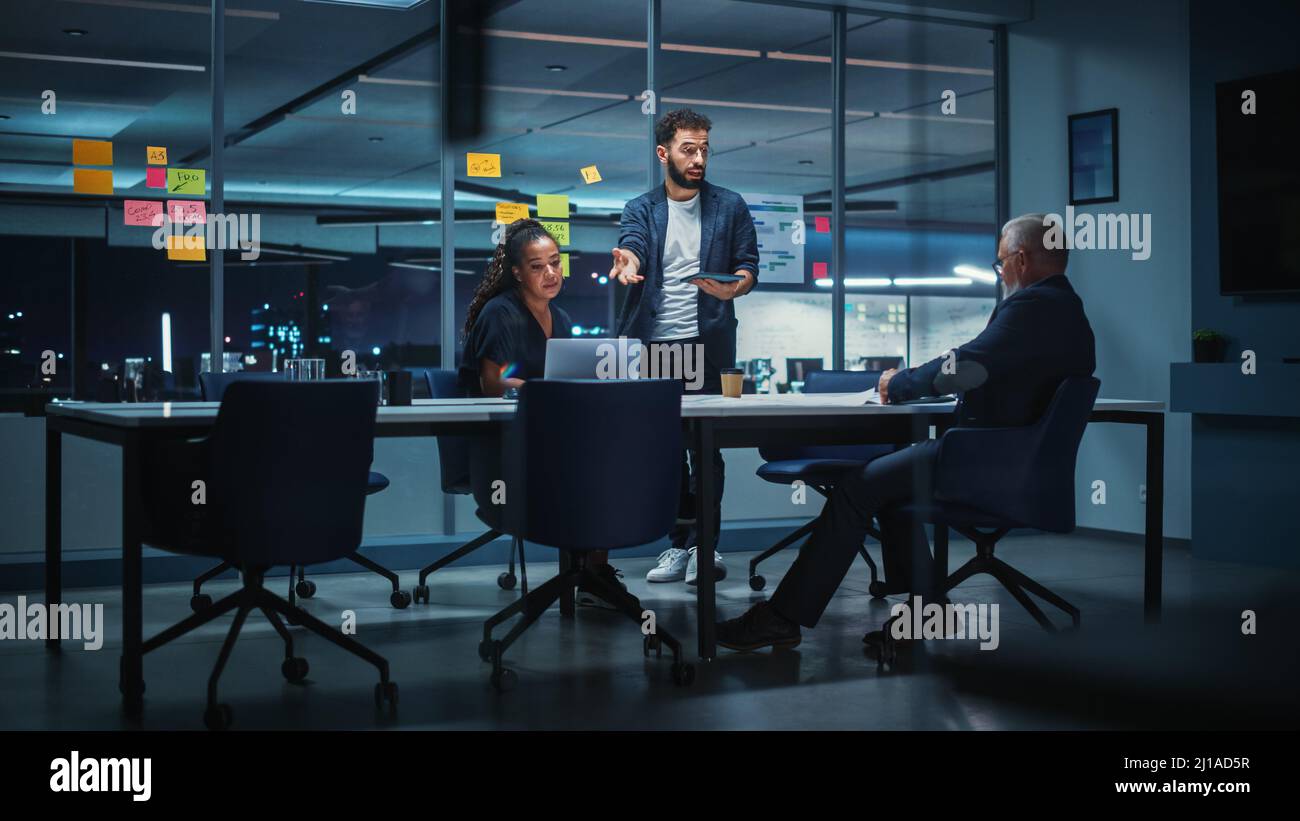 Office Conference Room Meeting: Diverse Team of Top Managers Talk; Brainstorm; Use Digital Tablet. Business Partners Discuss Financial Reports; Plan I Stock Photo