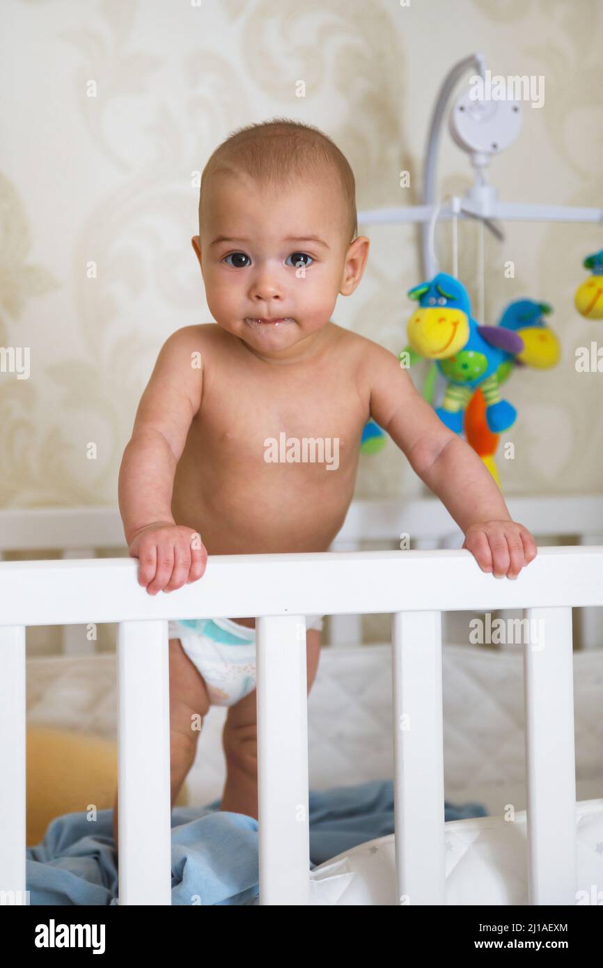 Cute baby first time standing up in his cot Stock Photo Alamy