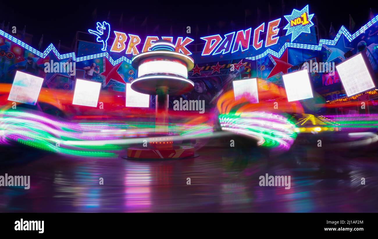 Breakdance on funfair at night in motion blur Stock Photo