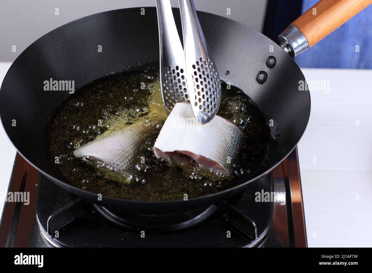 Put Milk Fish (Ikan Bandeng) into Hot Oil Using Stainless Tongs. Frying