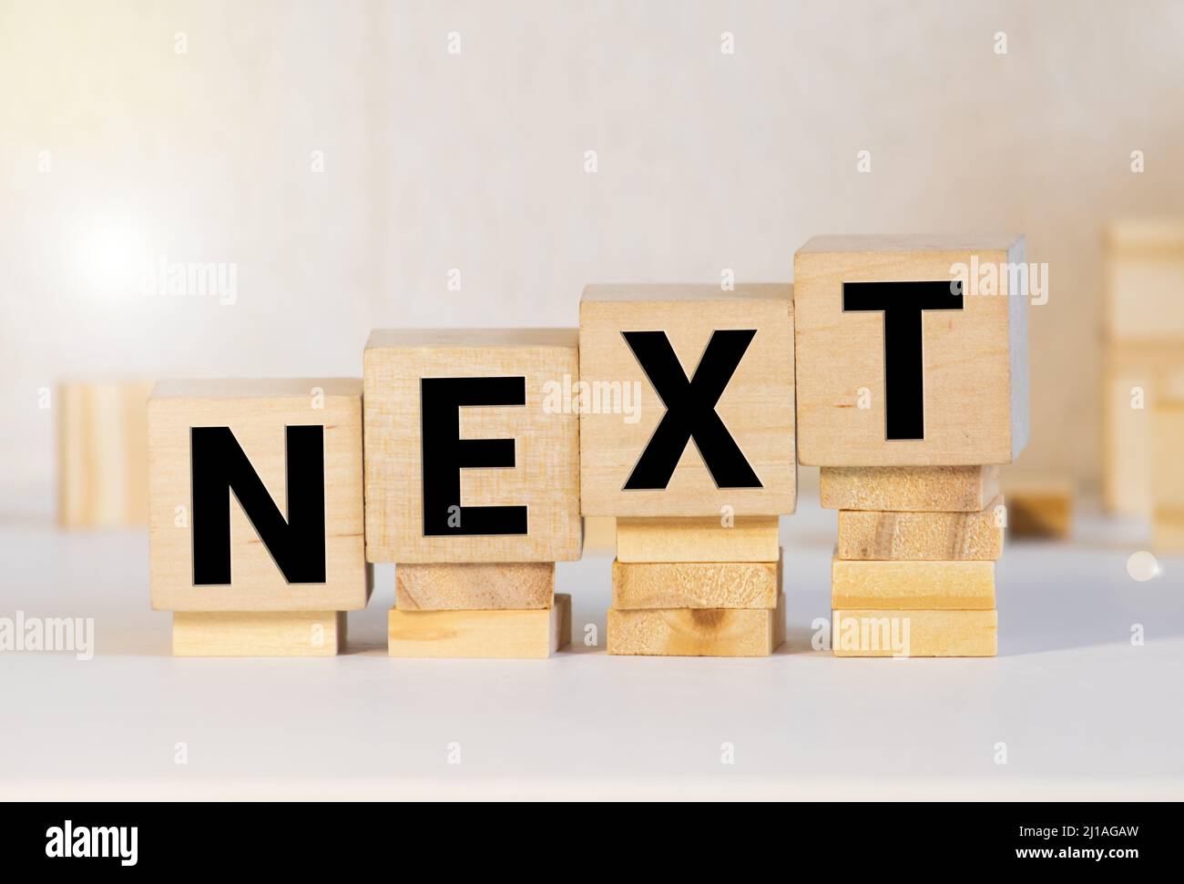 The word Next on wooden blocks on wooden table. Next steps plan ...