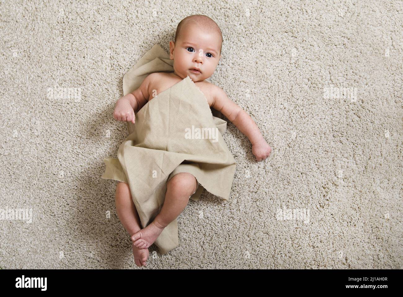Cute little baby covered with piece of linen fabric Stock Photo Alamy