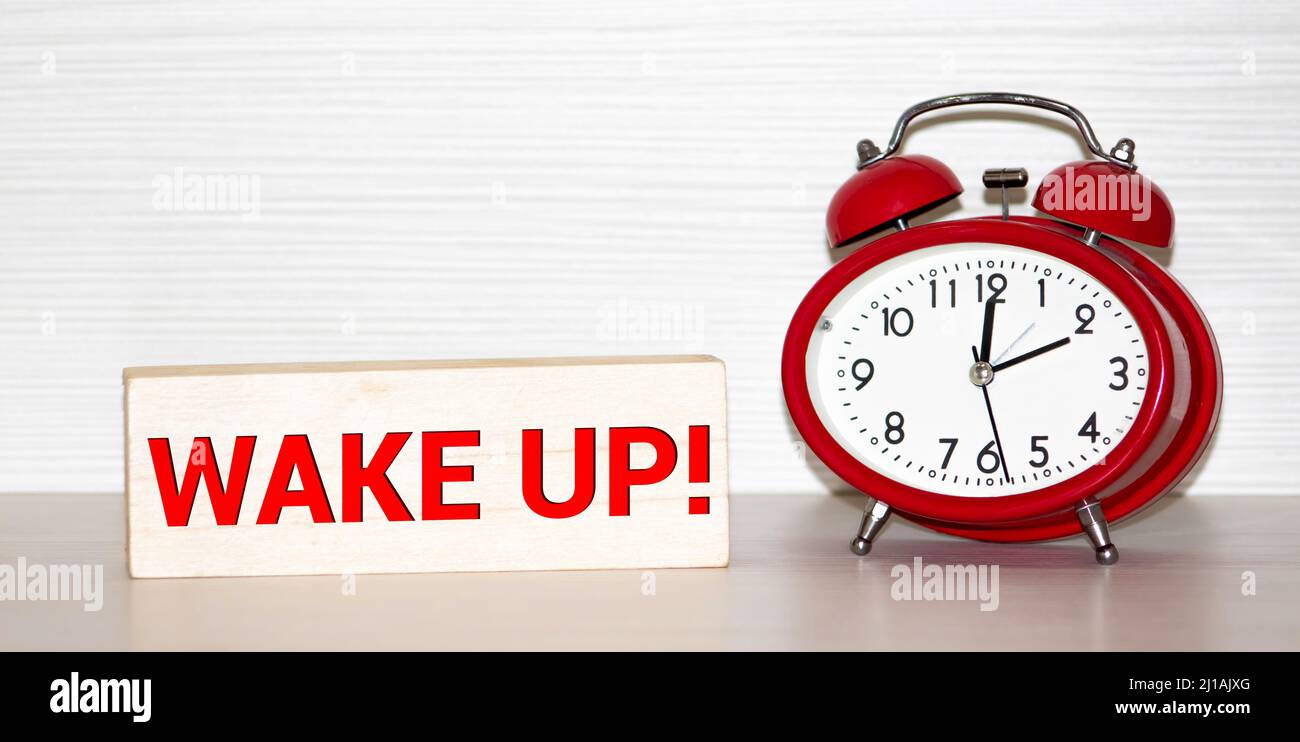Alarm clock with the words Oh wake up. The marker on the watch dial writes the word. Early waking concept Stock Photo