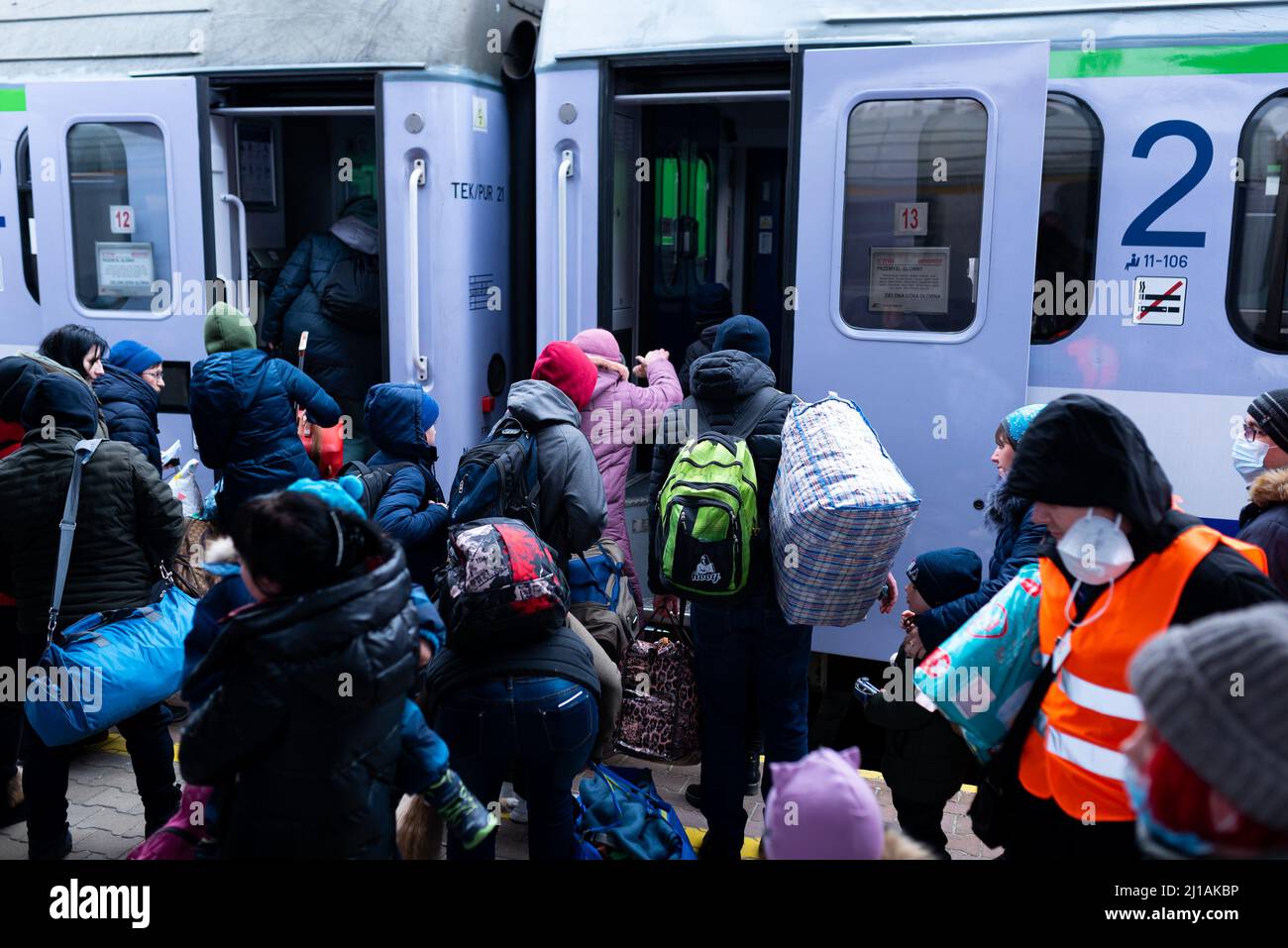 Refugees with suitcases board a train in Przemysil train station, close to the border with Ukraine, where refugees arrive by train as they flee the wa Stock Photo