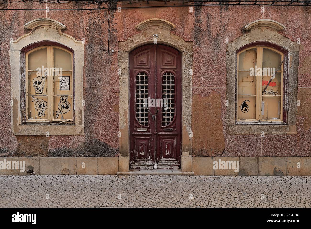 Paint faded windows-wooden door-façade of long abandoned Neoclassical townhouse. Faro-Portugal-159 Stock Photo