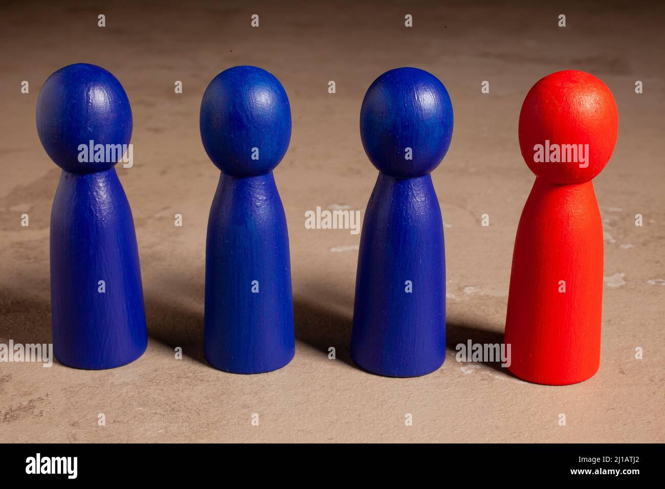Red skittle and three blues. Teamwork with outstanding team member or leader. Dare to be different. Standing out from the crowd Stock Photo