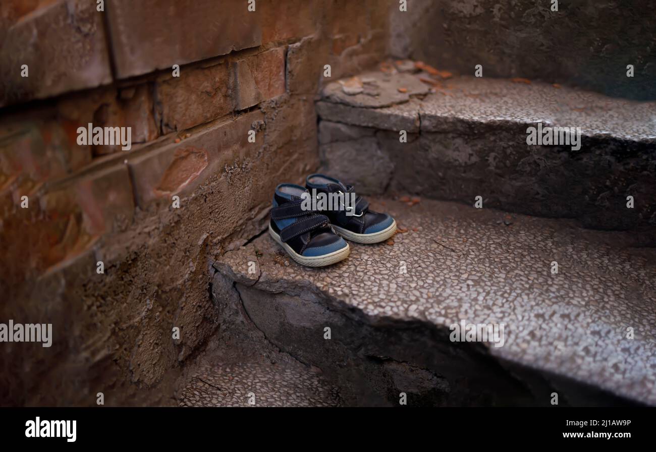 Kids shoes on representing civilian casualties in an active war zone Stock Photo