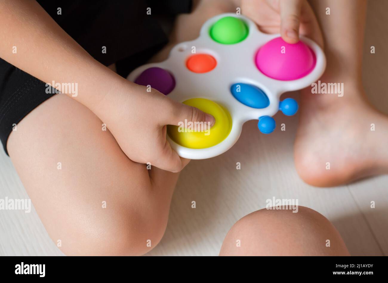 A child plays with a simple dimple, close-up, selective focus. Children's  hands hold a modern simple dimple Stock Photo - Alamy