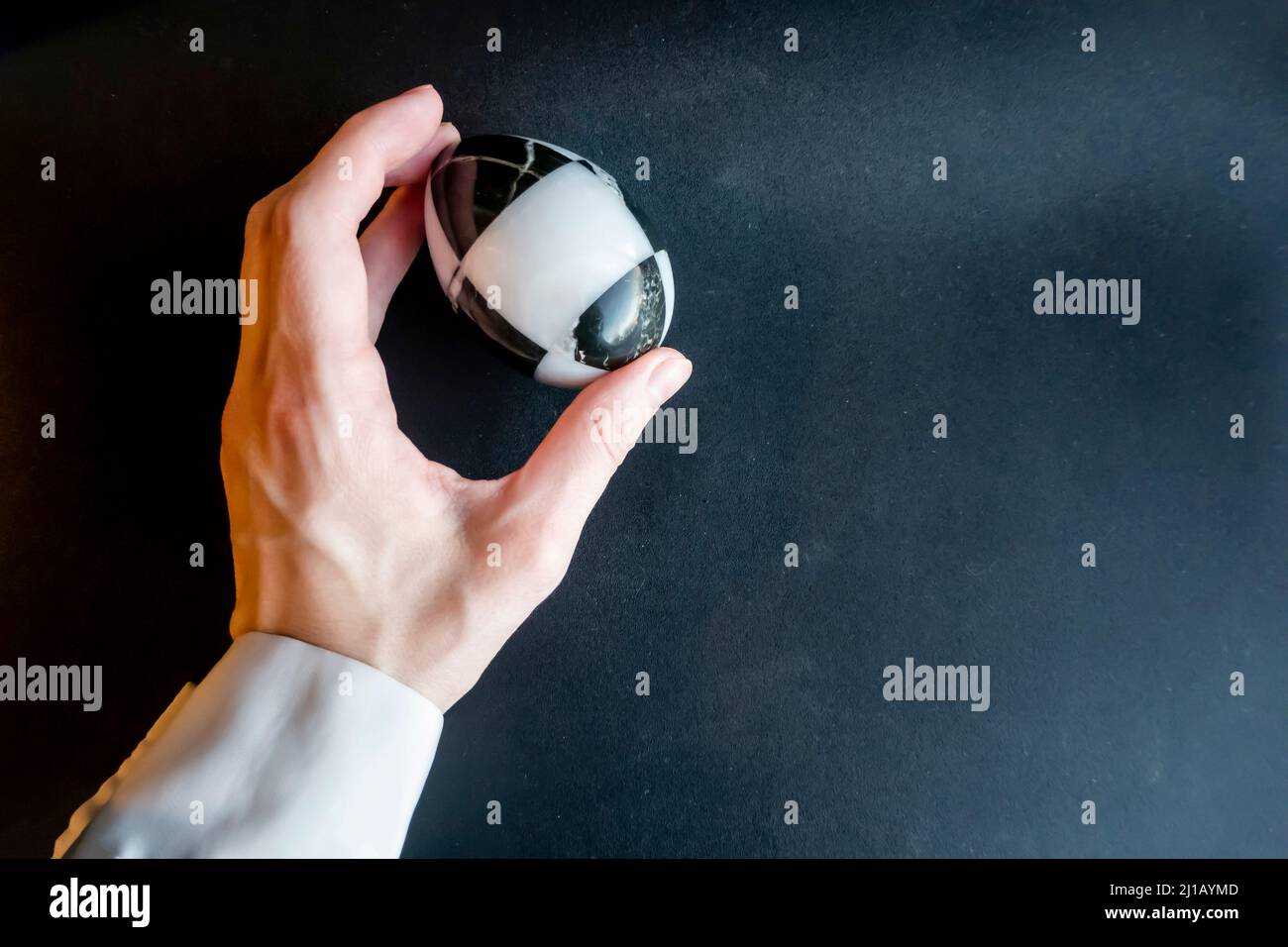 marble stone egg in hand on a black background. Easter theme Stock Photo