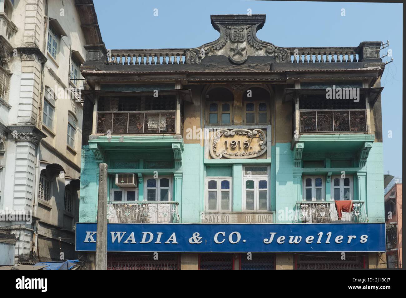 A ramshackle, dilapidated house built in 1915, housing amongst others K. Wadia & Co. Jewellers; Grant Road area, Mumbai, India Stock Photo