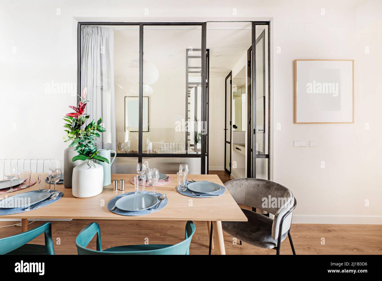 Wooden dining table with tableware set in front of black metal and ... - Mutually Exclusive Dining Table Installation In The Bedroom