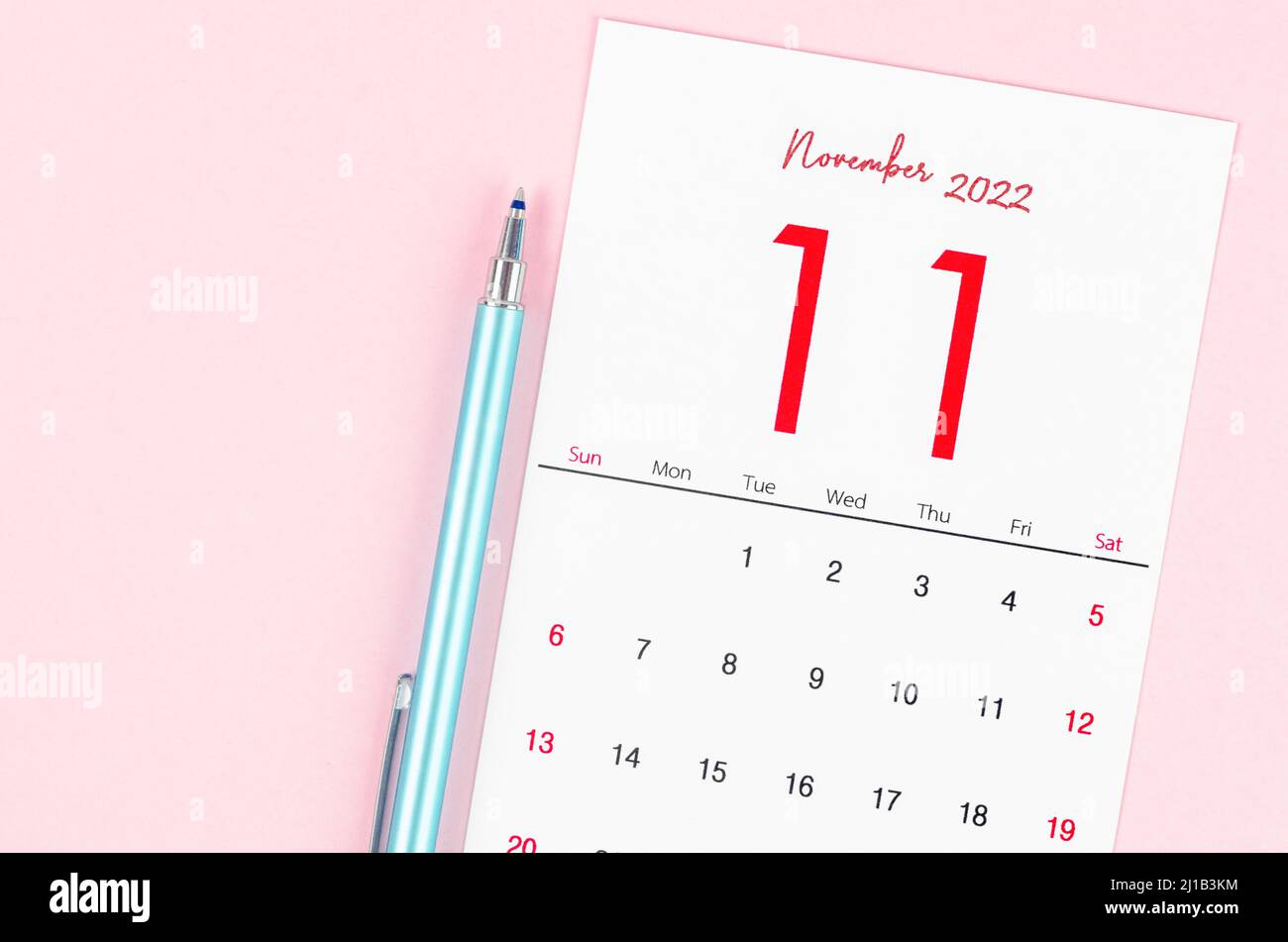 The November 2022 calendar with pen on pink background. Stock Photo