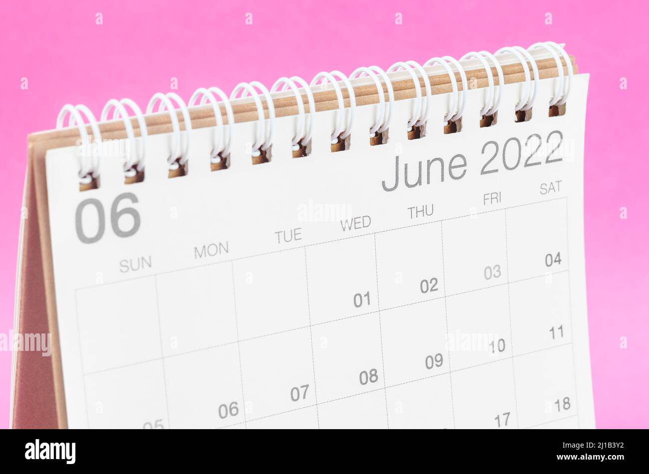 The June 2022 desk calendar on pink background with empty space. Stock Photo