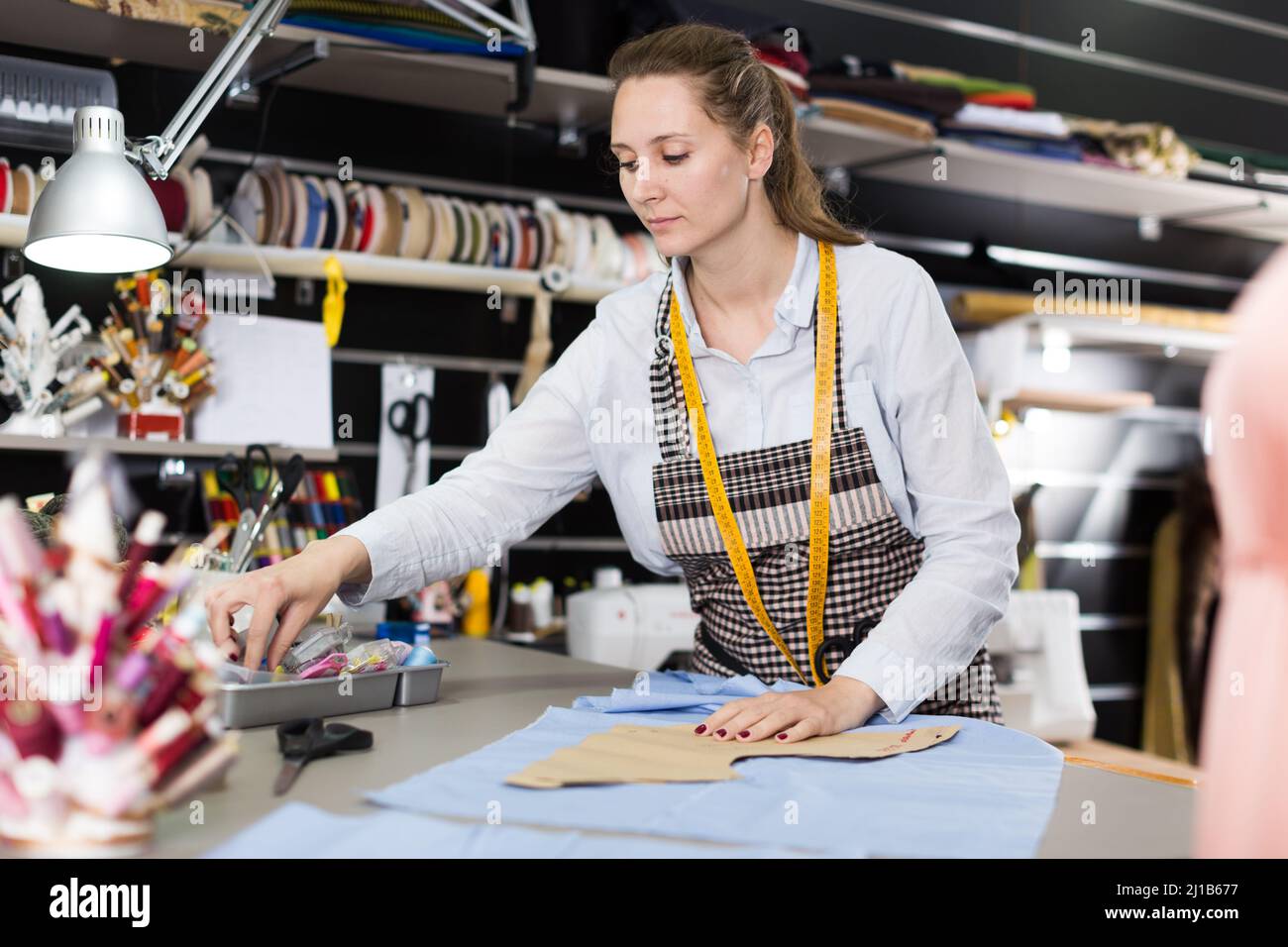 Positive tailor working with marker for modeling clothes at