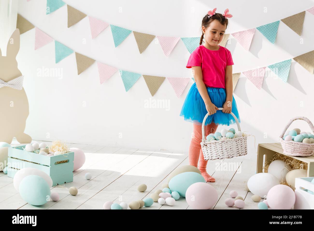 Cute little girl with bunny ears and basket of Easter eggs Stock Photo ...