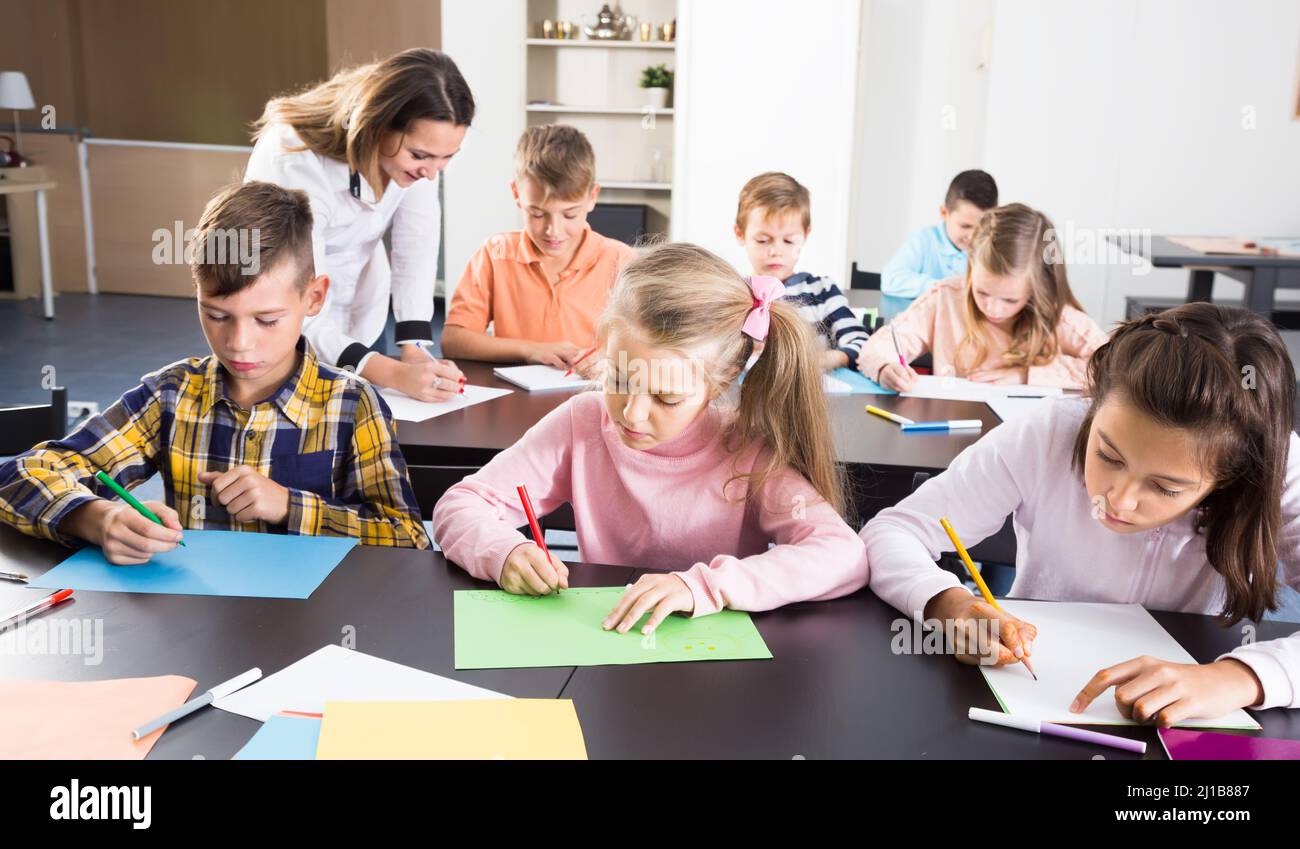 smiling little kids with teacher drawing in classroom Stock Photo - Alamy