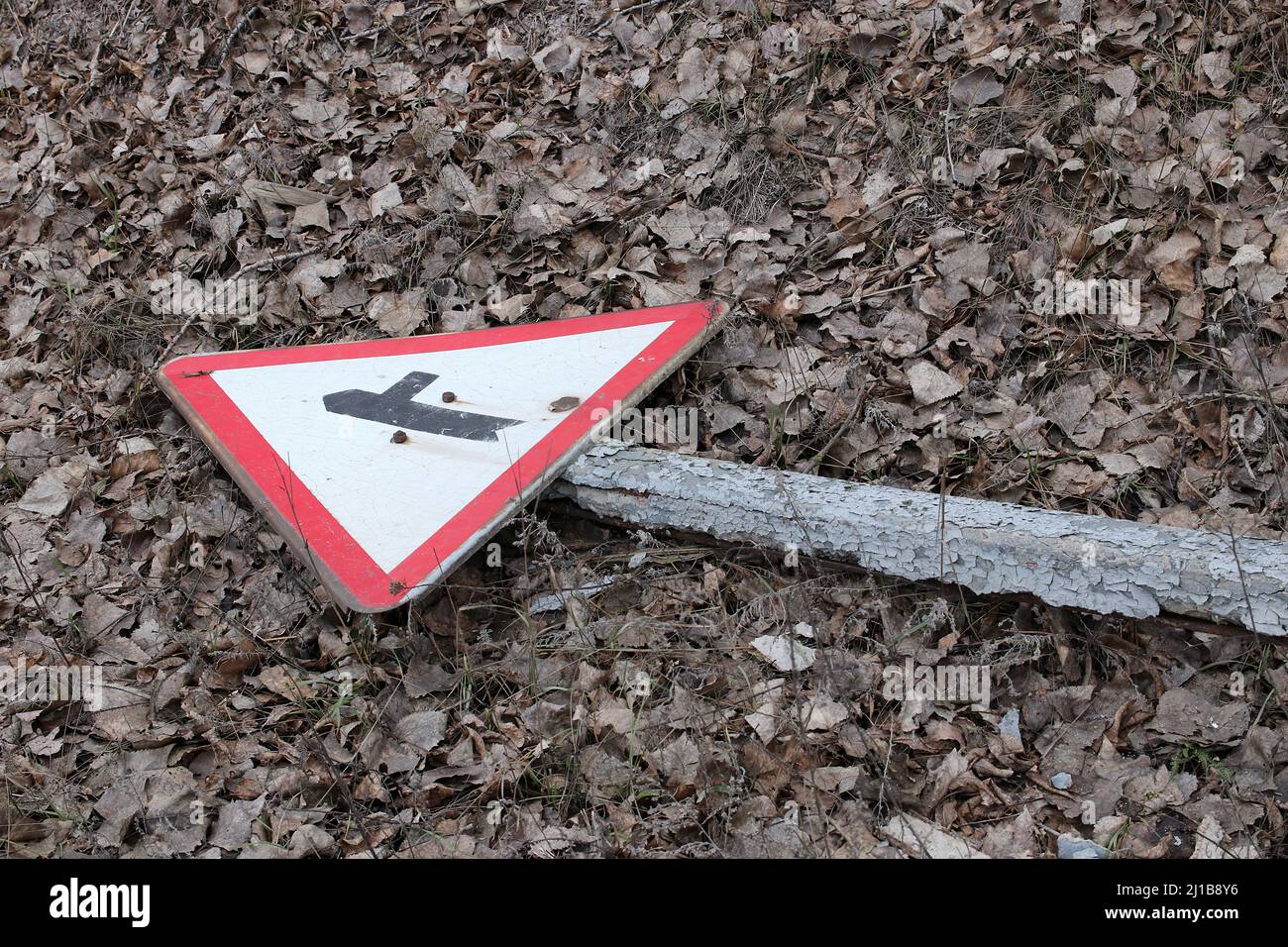 Broken Road Sign. Road sign lying on the ground. Stock Photo