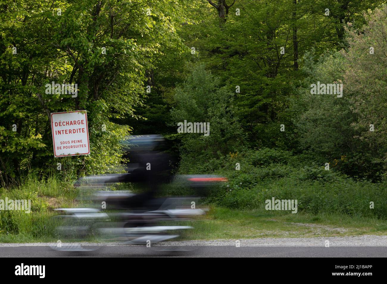 MOTORCYCLE IN FRONT OF THE FOREST WITH A SIGN SAYING NO LITTERING – SUBJECT TO PROSECUTION, RUGLES, EURE, NORMANDY, FRANCE Stock Photo
