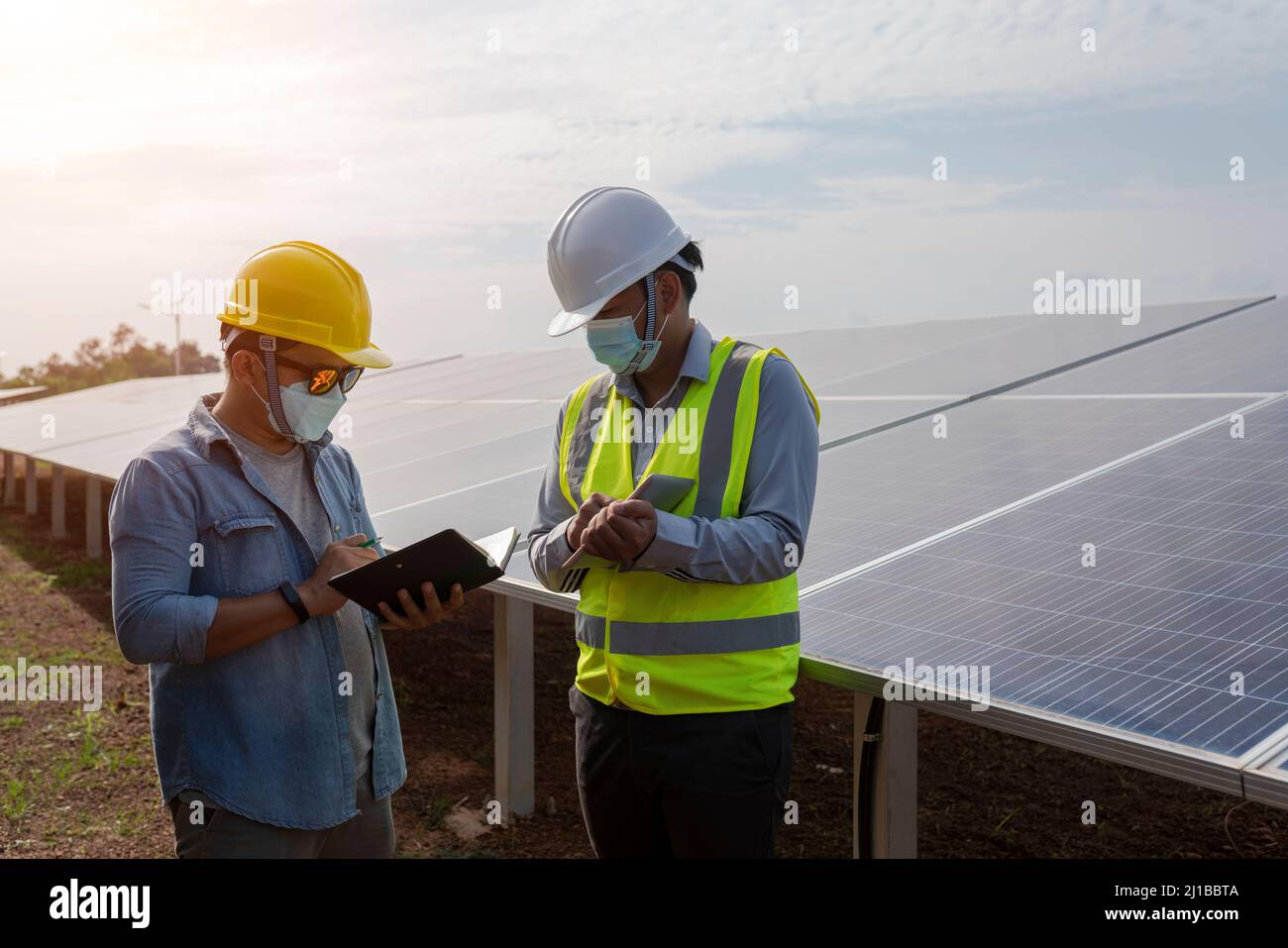 Engineers and technicians work on planning to power solar panel renewable power plants. Stock Photo