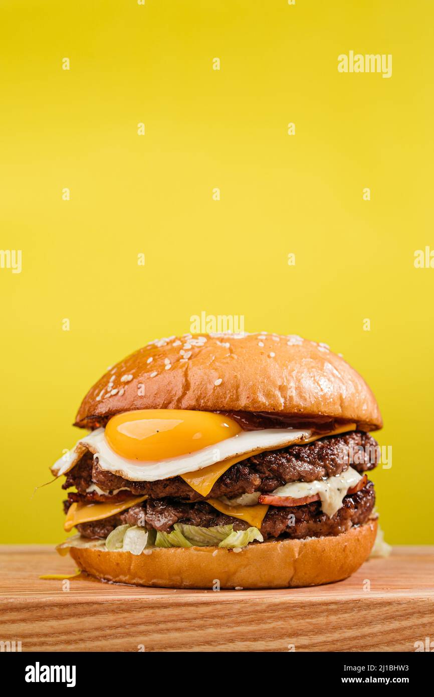 Double patty burger with marbled beef, bacon, cheddar cheese, fried egg