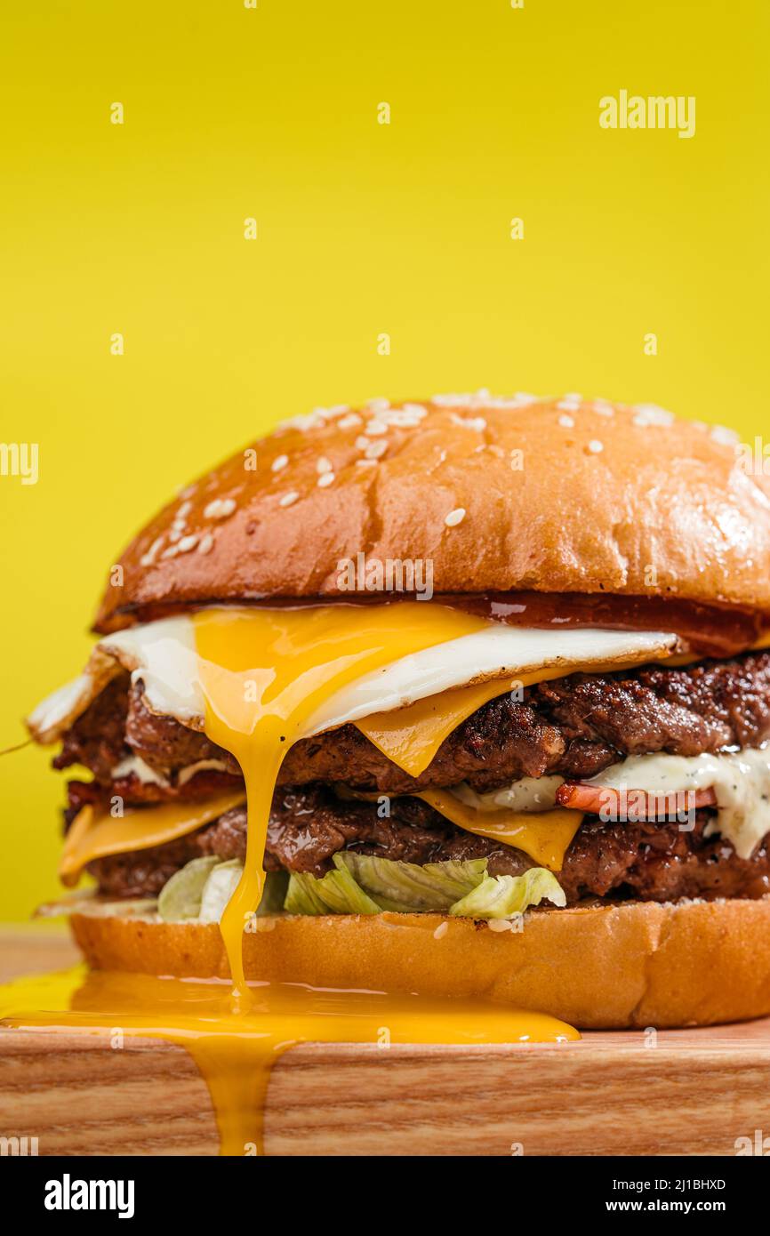 Double patty burger with marbled beef, bacon, cheddar cheese, fried egg with running yolk