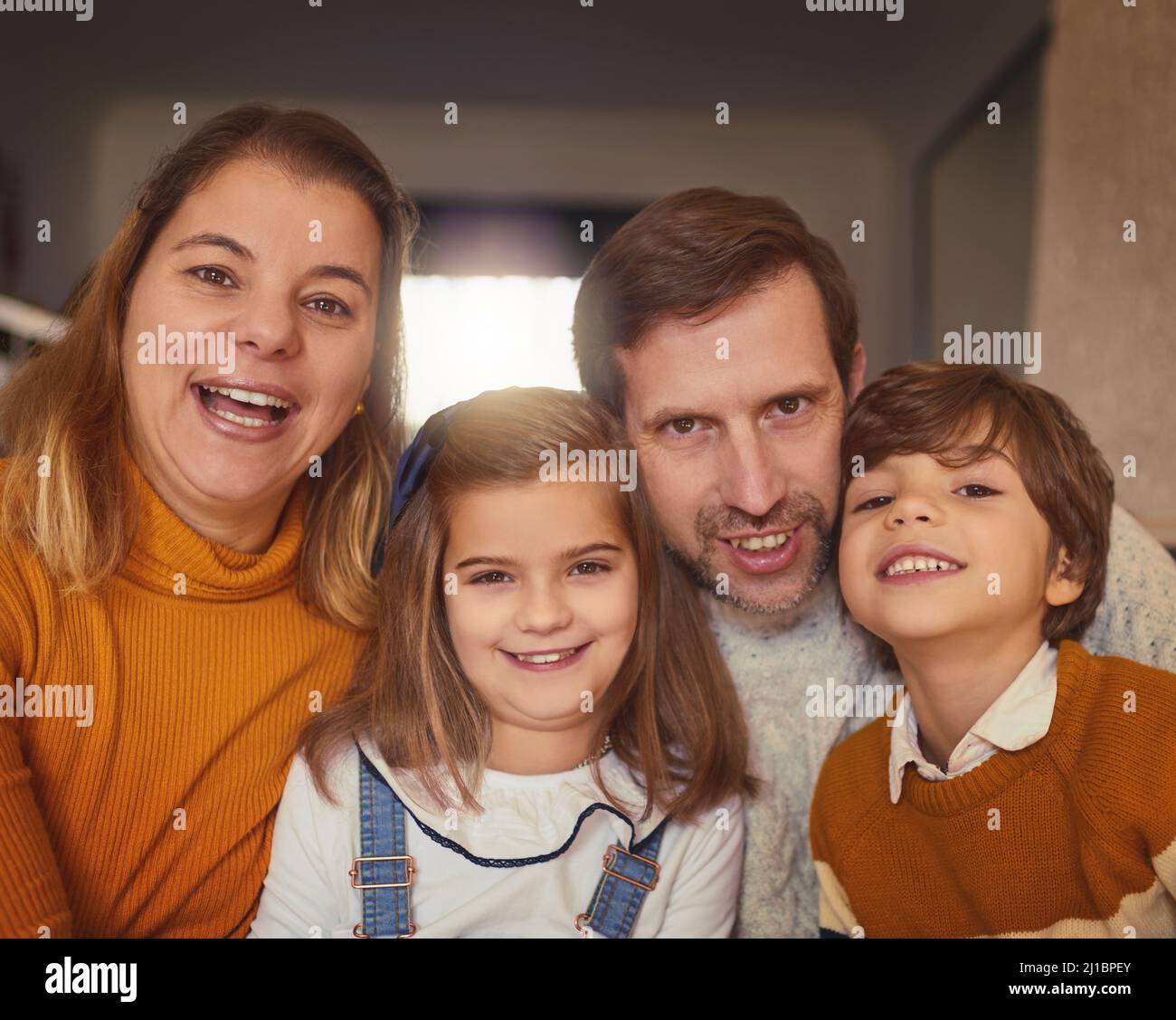 We are one happy family. Cropped portrait of an affectionate young family of four sitting on the sofa at home. Stock Photo