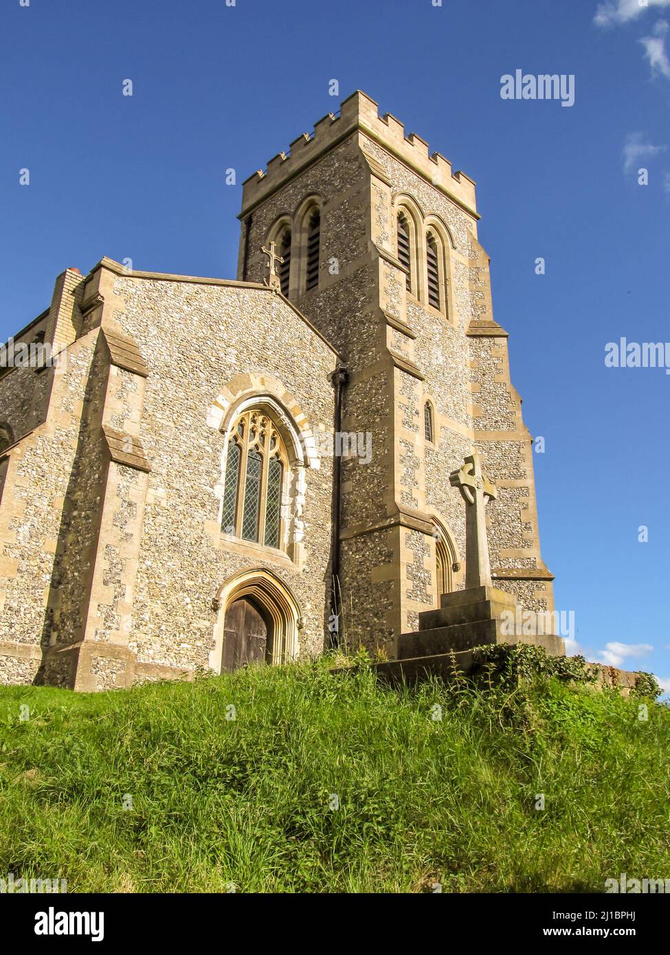 Looking up at the 15th Century Ellesborough church, on a small grassy hill, against a clear blue sky, inn the Chiltern Hills, England, UK Stock Photo