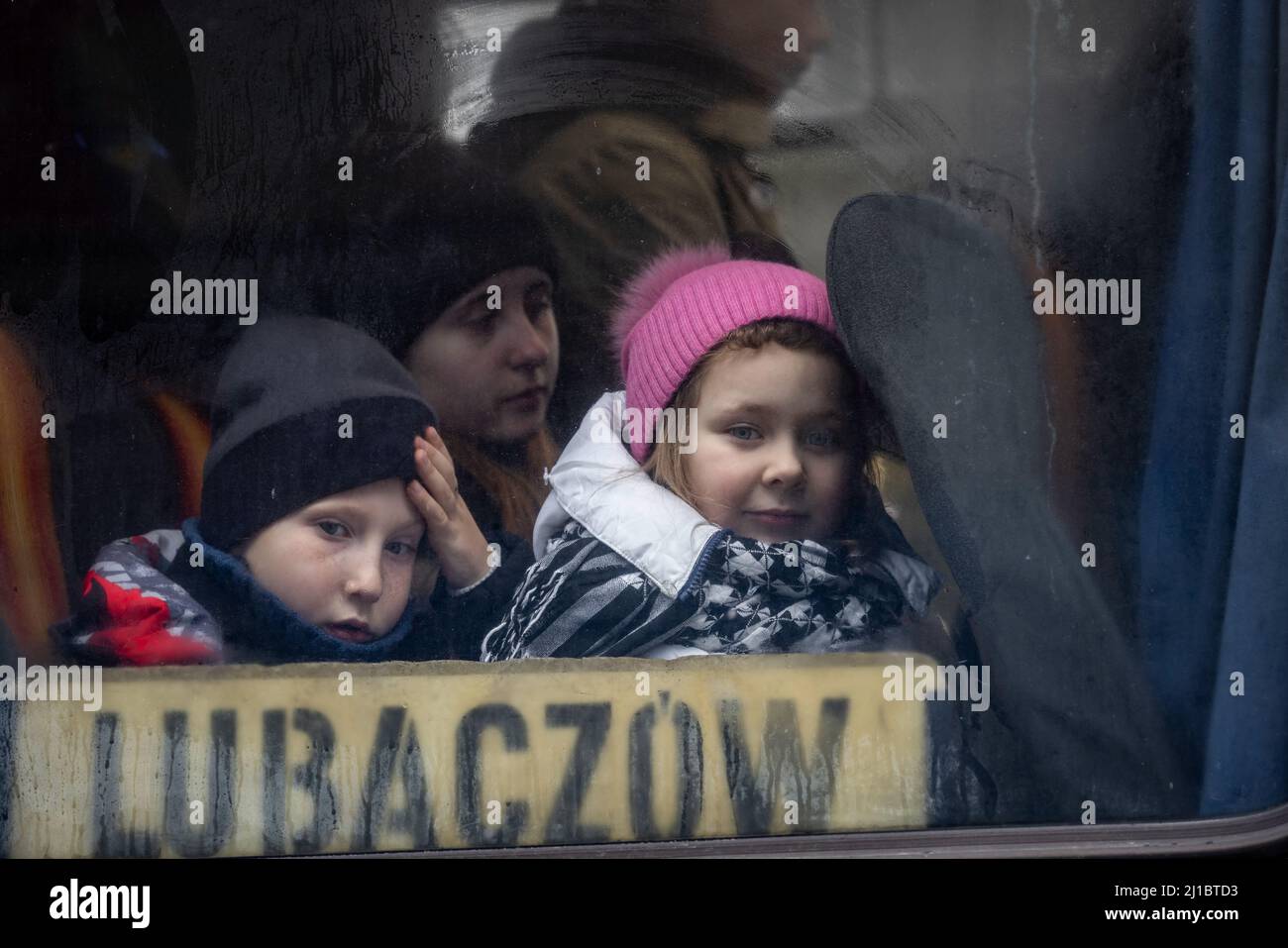 Refugees from Ukraine have reached the central refugee collection point in a logistics center near Korczowa in the Polish-Ukrainian border area. Here they are supplied with food and clothing and then transported onward by bus to other cities. Stock Photo