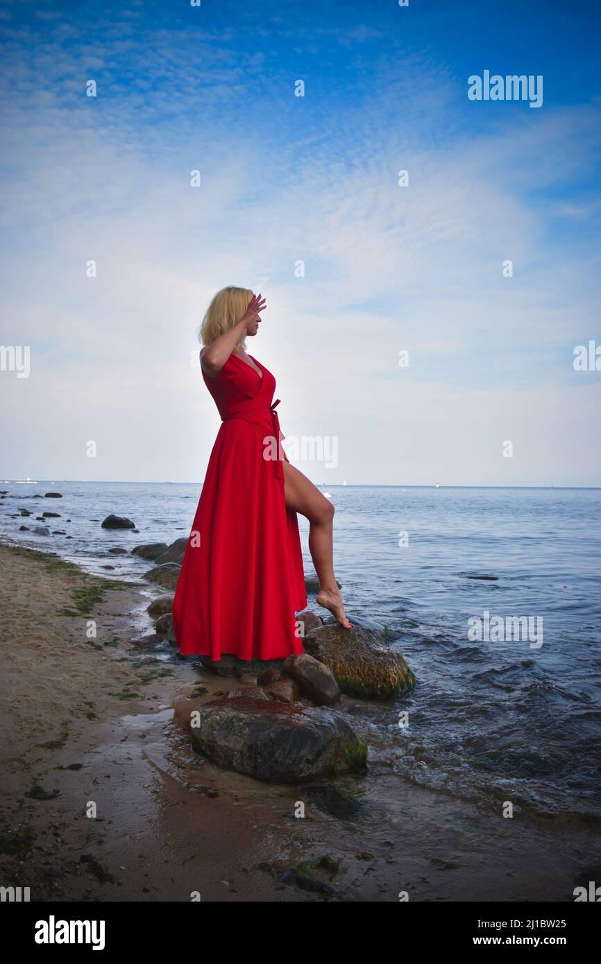 Summer concept with a beautiful woman. The blonde haired girl on the shore of the Polish sea. Stock Photo