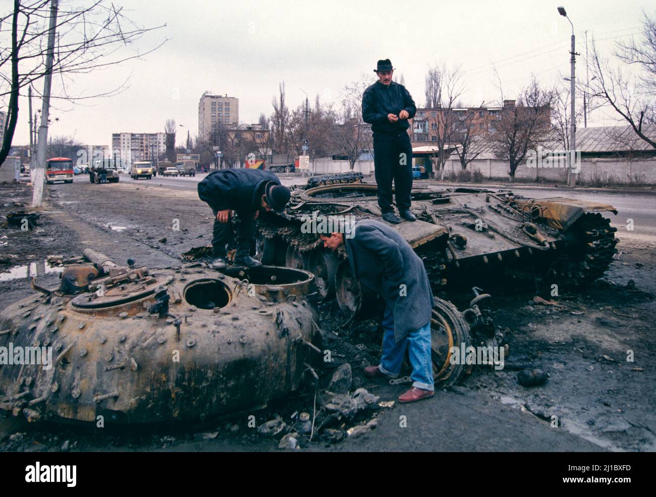 First Chechen War, November 1994.  Civilians look at a destroyed Russian T-72 tank on the street in Grozny, Chechnya. Stock Photo
