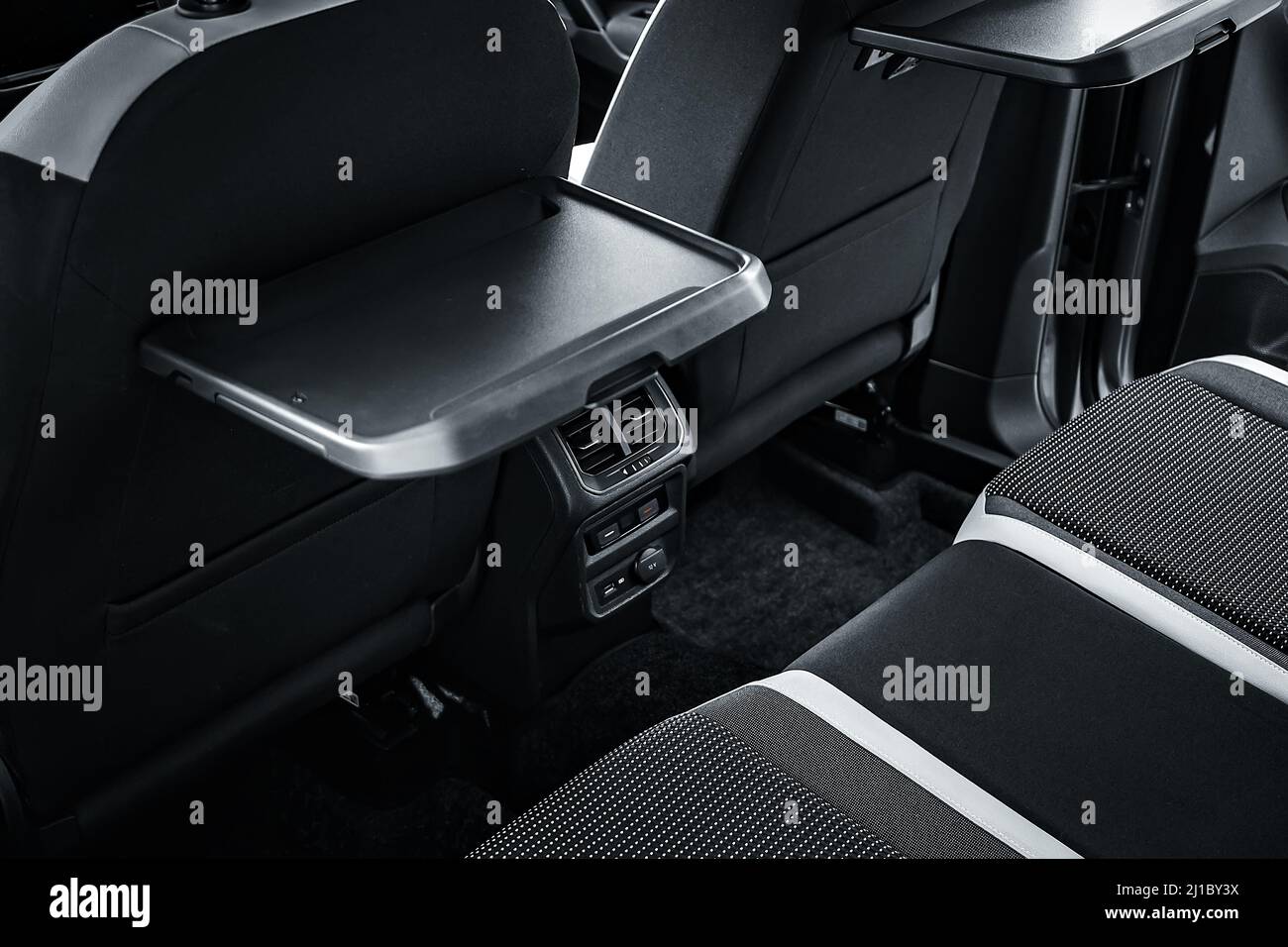 Interior of new car is viewed from inside. Passenger seats in back. Sofa and empty space. Background Stock Photo