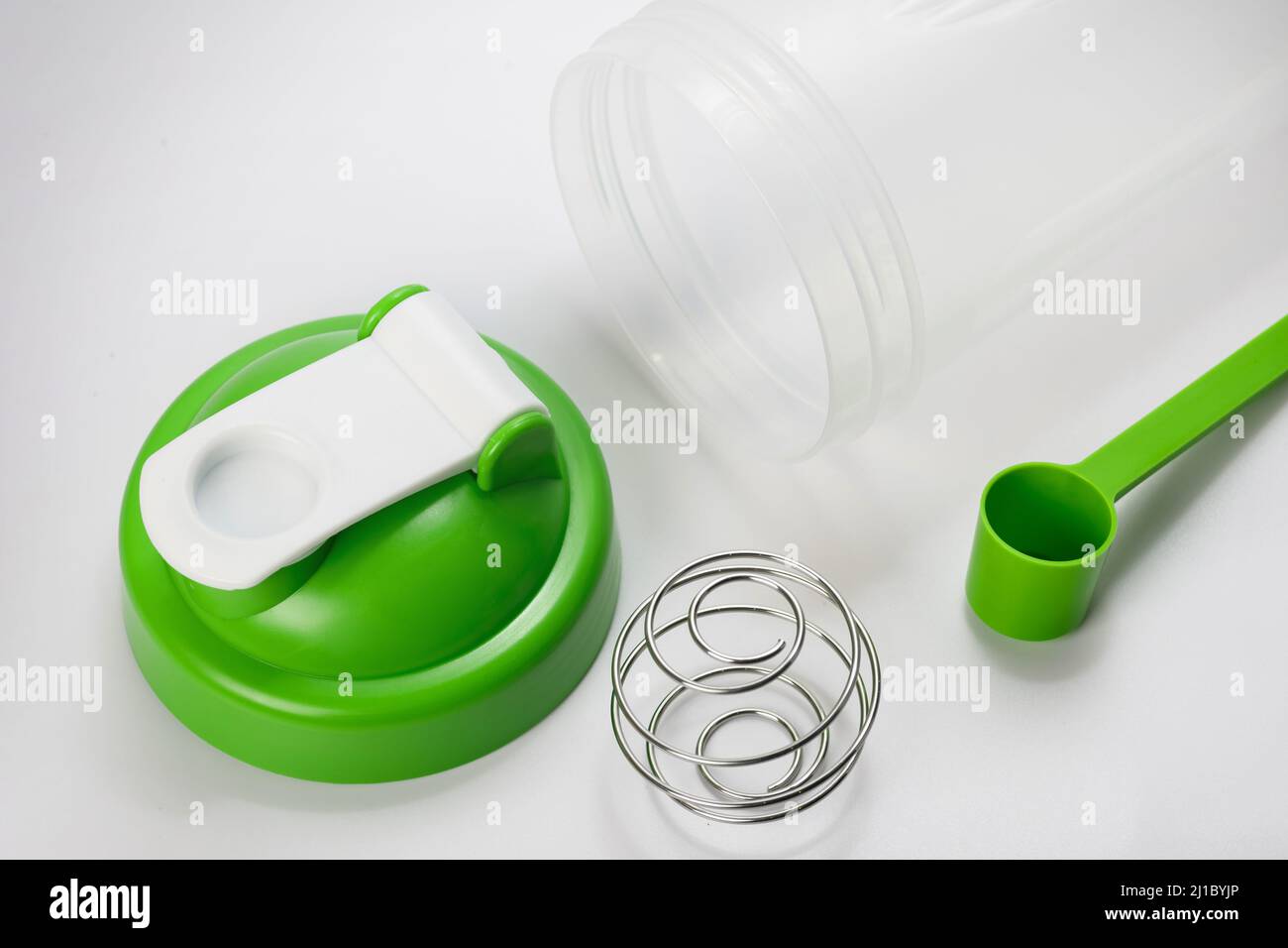 Green protein shaker and scoop on white Stock Photo Alamy