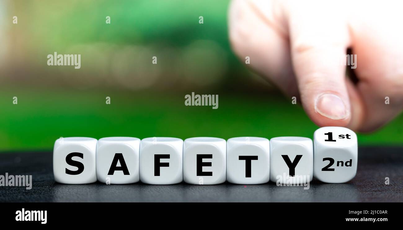 Hand turns a dice and changes the expression 'safety 2nd' to 'safety 1st'. Stock Photo