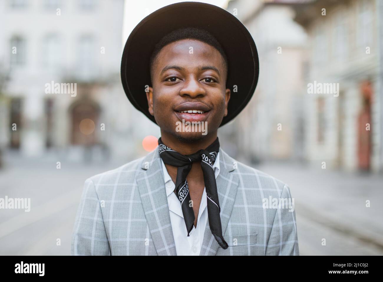 Handsome african man wearing stylish suit, black hat and rings standing ...