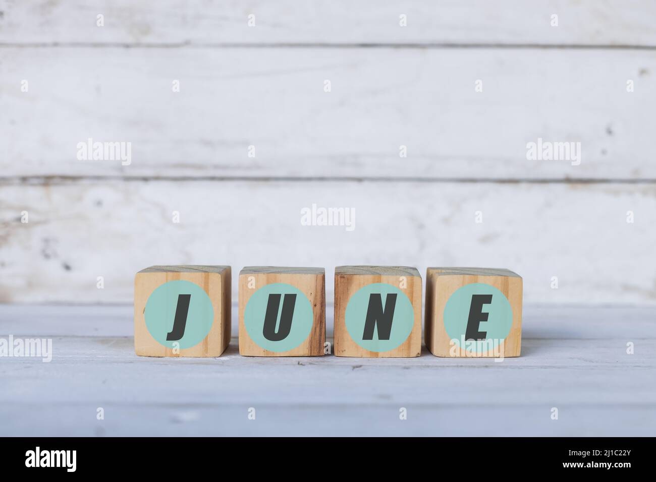 june concept written on wooden cubes or blocks, on white wooden background. Stock Photo