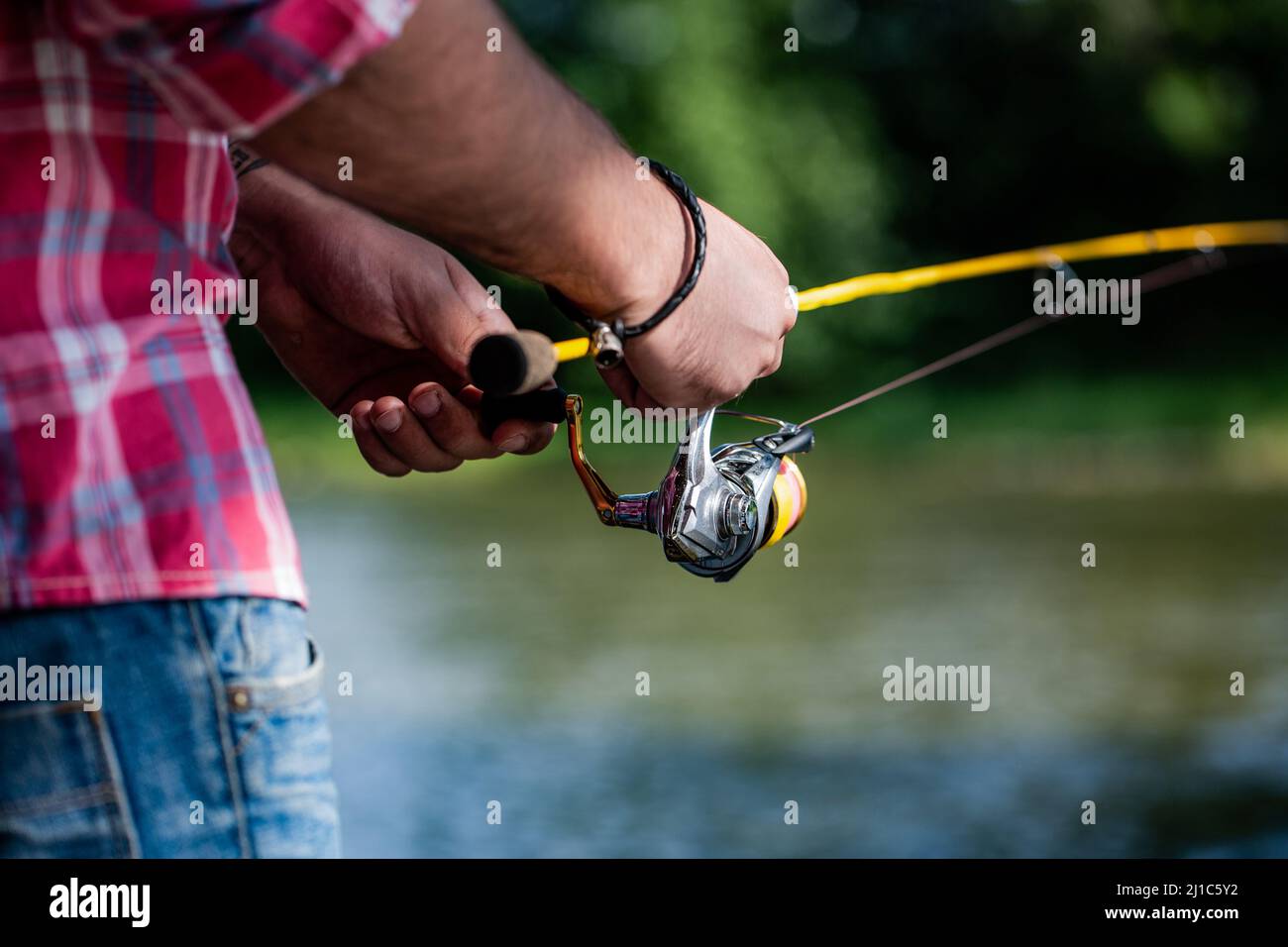 https://c8.alamy.com/comp/2J1C5Y2/fishing-reel-fishing-rod-with-aluminum-body-spool-fishing-gear-fish-supplies-and-equipment-fishings-reel-close-up-on-the-background-of-the-river-2J1C5Y2.jpg