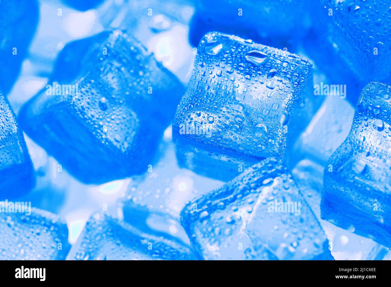 Ice made of cubes lined up with drops on a blue background Stock Photo